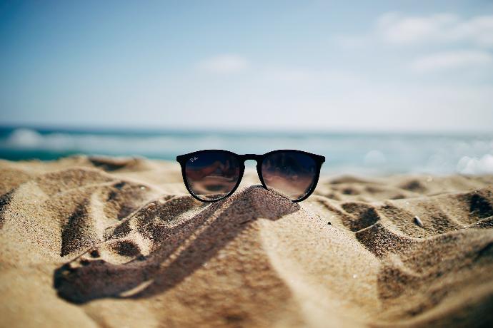 zwarte Ray-Ban Wayfarer-zonnebril op een zandstrand